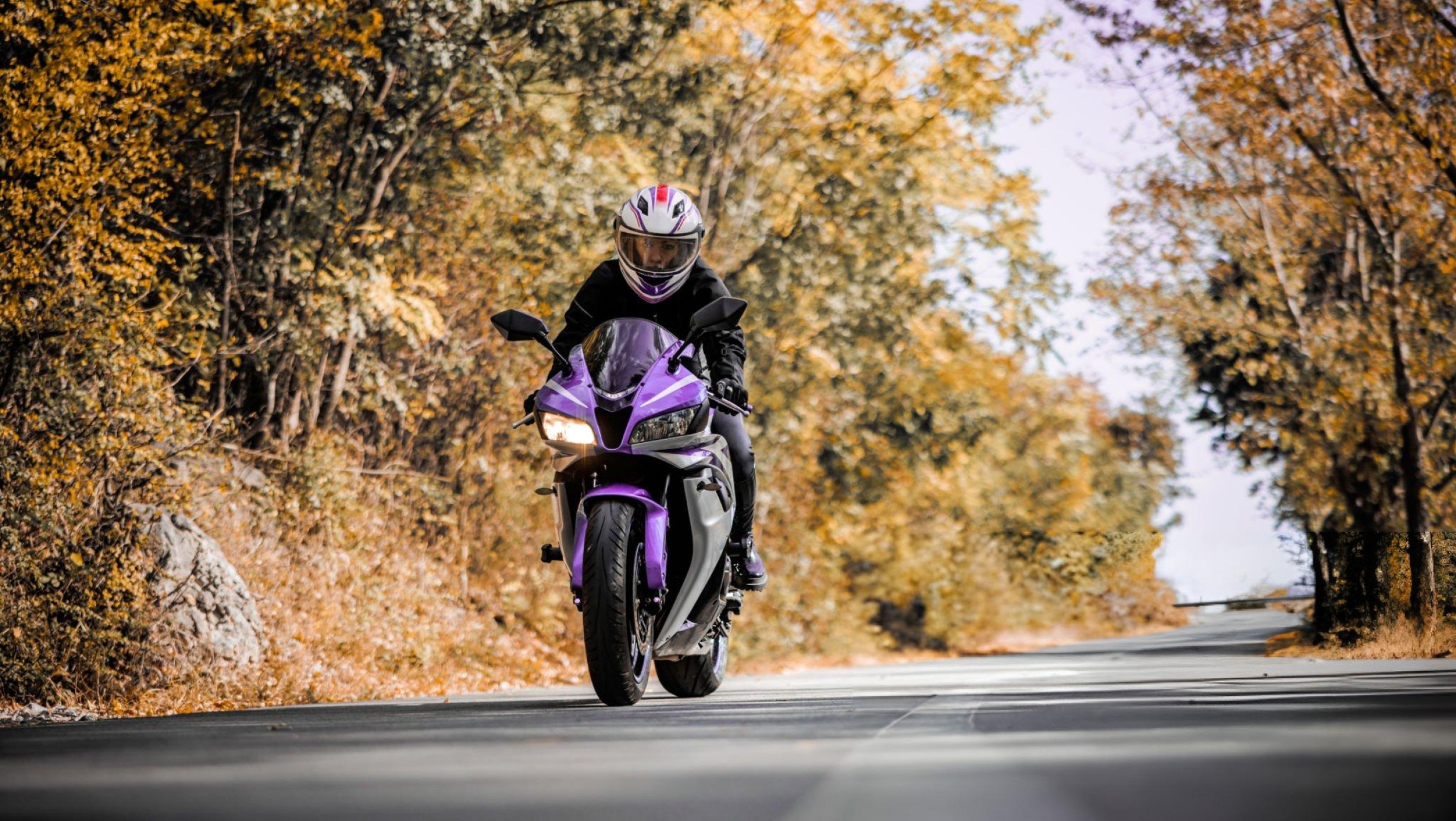 Hero image of a brand‑neutral 125cc motorcycle on an open road, speedometer view hinting 55–75 mph top speed, with city-to-highway backdrop