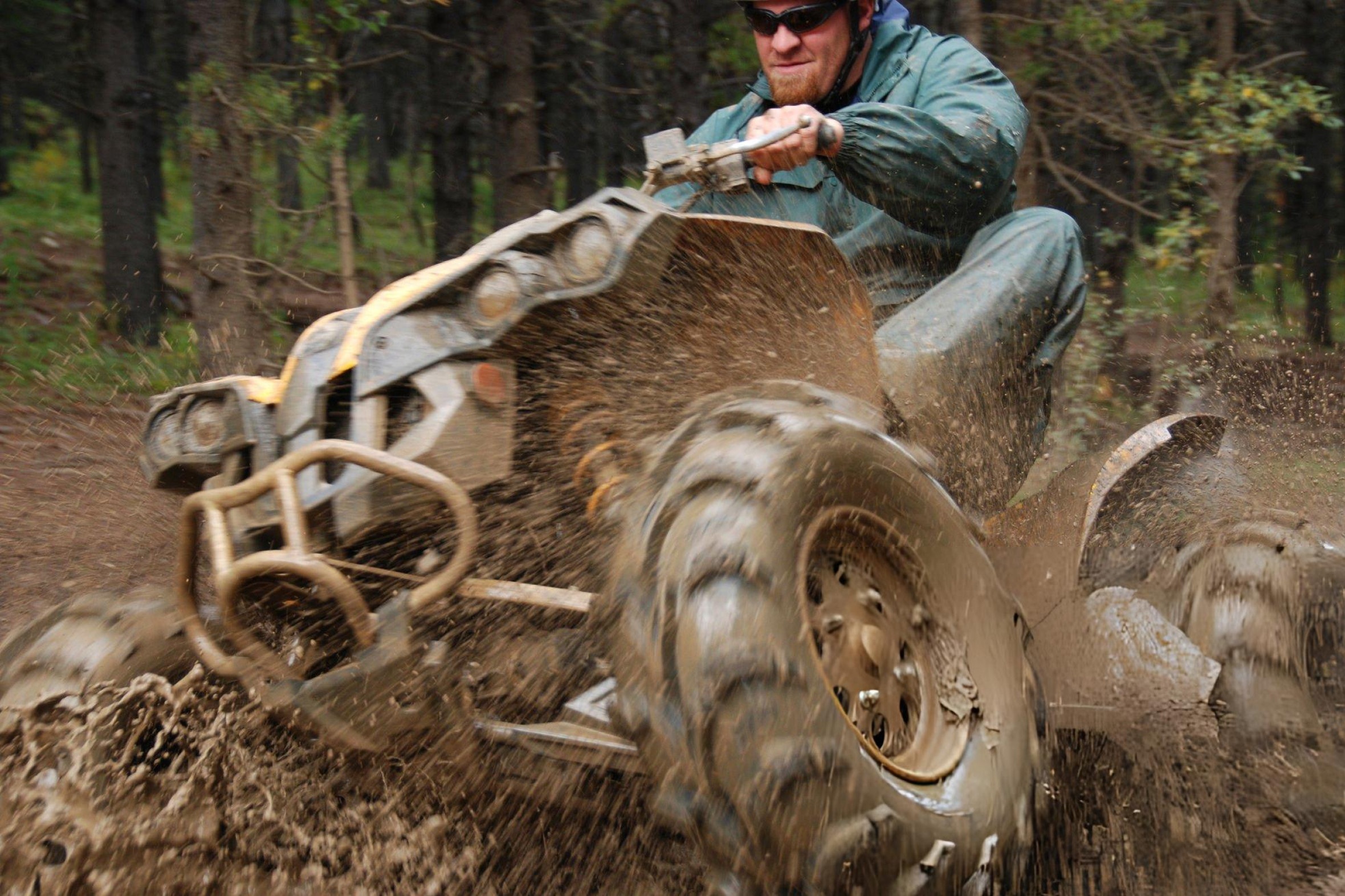 Split-screen comparison of an ATV on a muddy trail and a quad on sand dunes, highlighting their differences in terrain and purpose.