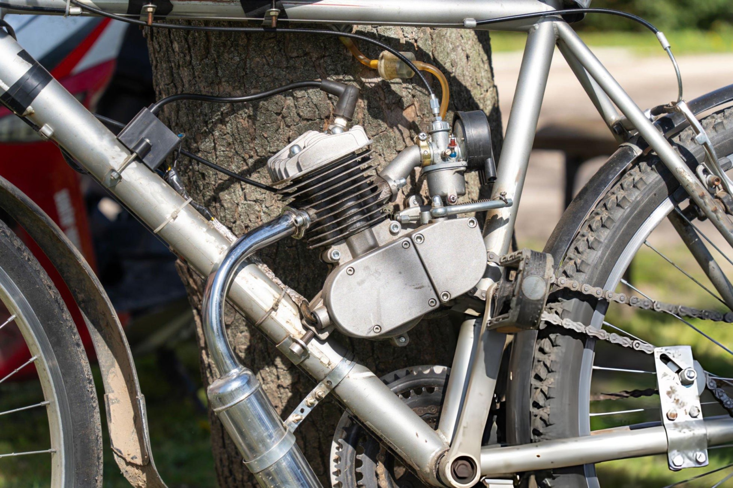 Mechanic diagnosing a bogging two stroke dirt bike engine in a workshop